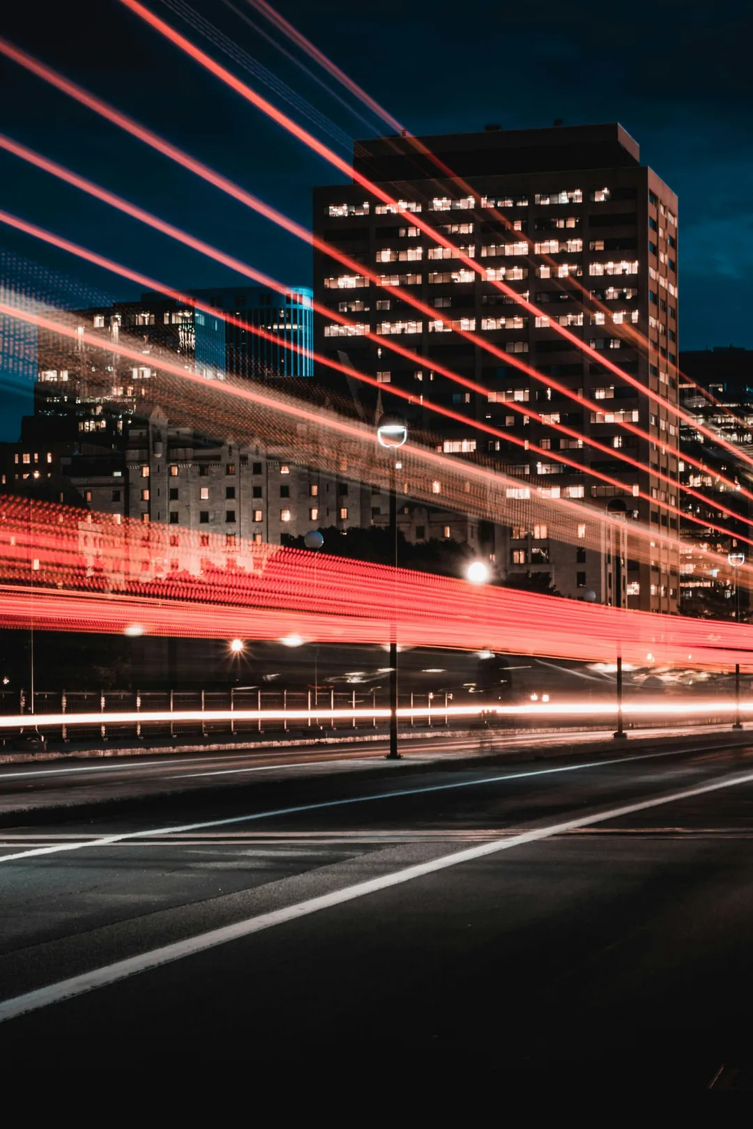 Lichtspuren des Verkehrs vor einer Stadtkulisse bei Nacht